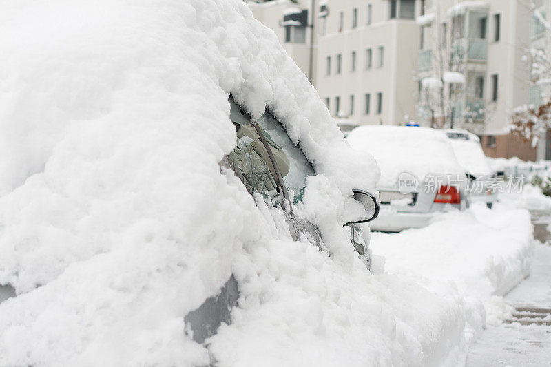 城市街道上的汽车被雪覆盖着