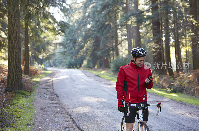 骑自行车的人在森林里用手机