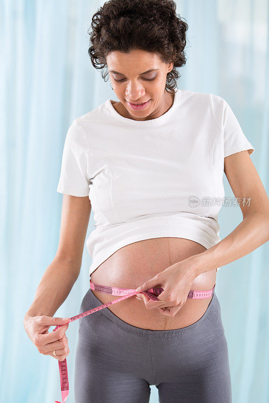 正在测量腰围的孕妇