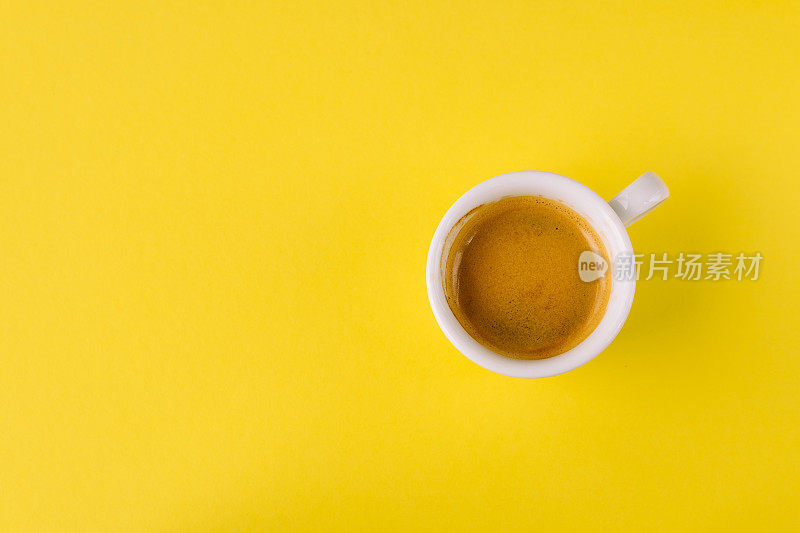 淡黄色背景上的小杯咖啡