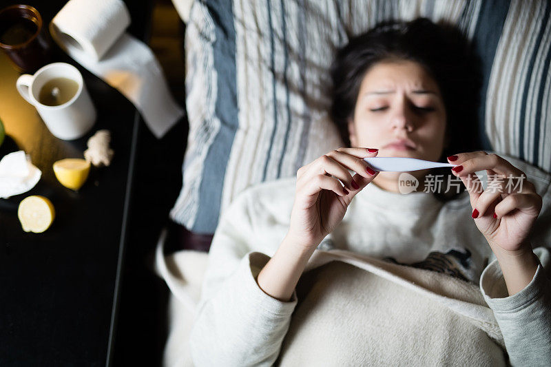 流感。女人感冒了病毒生病的女人躺在床上盖着羊毛毯子