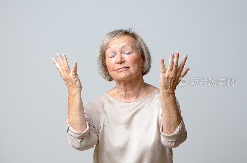 一位年长的女士双手举向天空
