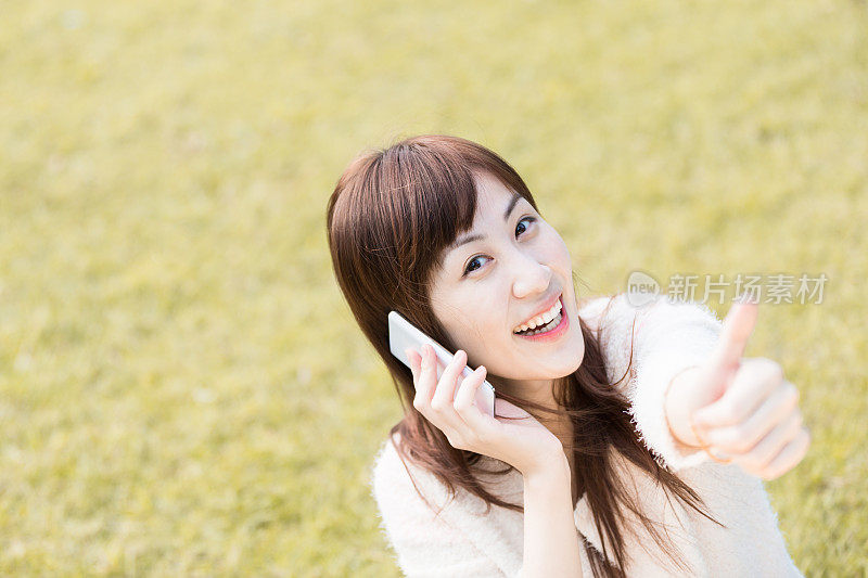 年轻漂亮的亚洲女人在用智能手机聊天