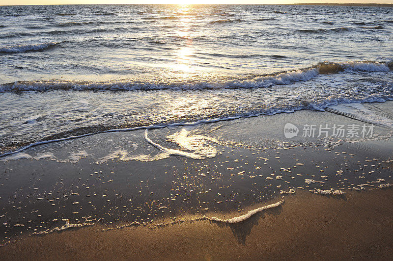 夕阳下海滩上柔和的浪花