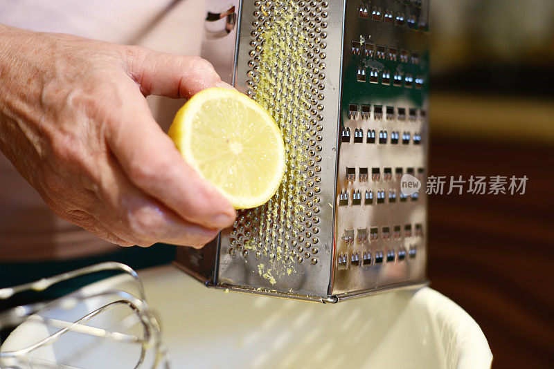 在厨房刨丝器上擦柠檬。