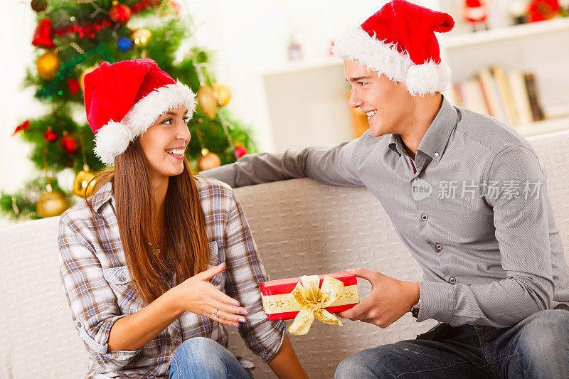 一个年轻人给他的女朋友一个圣诞礼物。