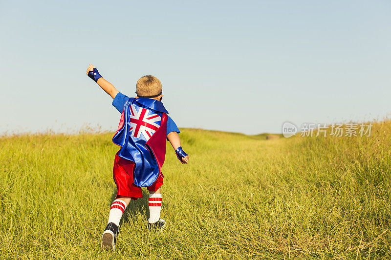 装扮成超级英雄的英国小男孩正在跑步