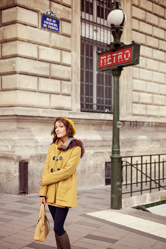 年轻时尚的女人在巴黎街头的地铁附近等待。