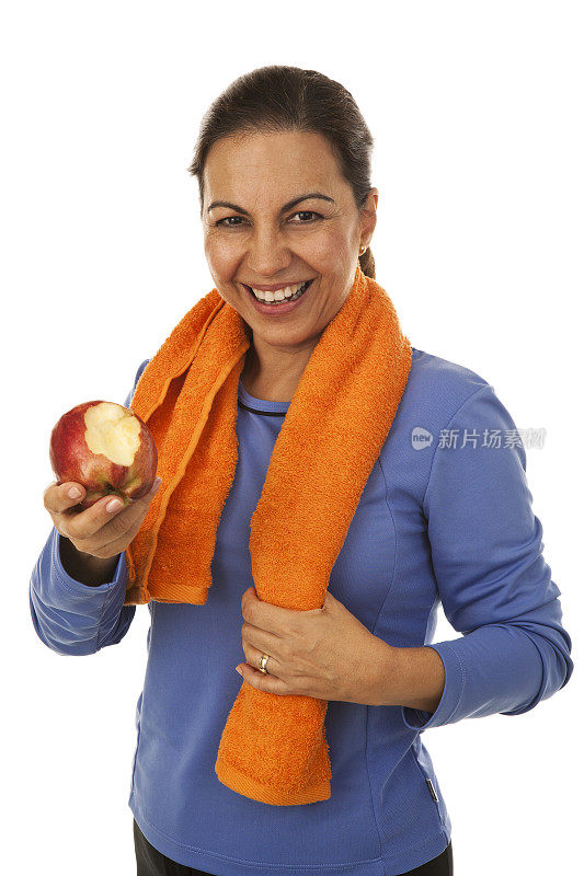 中年妇女穿着运动服拿着苹果咬