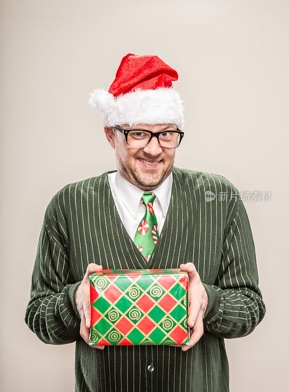 笨拙的书呆子圣诞老人拿着包装好的节日礼物