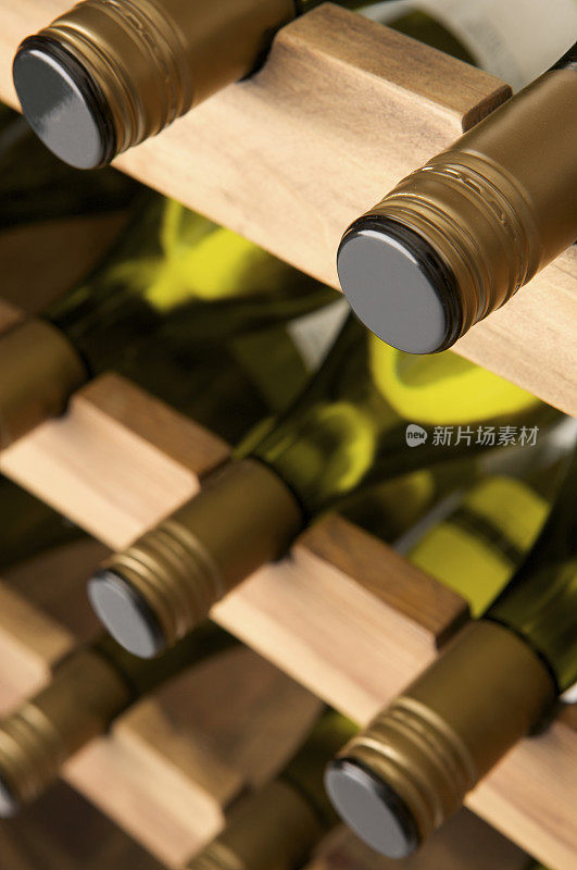 白葡萄酒酒瓶放在一个大木架子上。