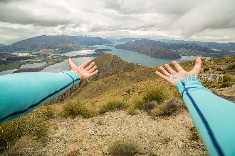 女人的手臂伸向山和湖的风景