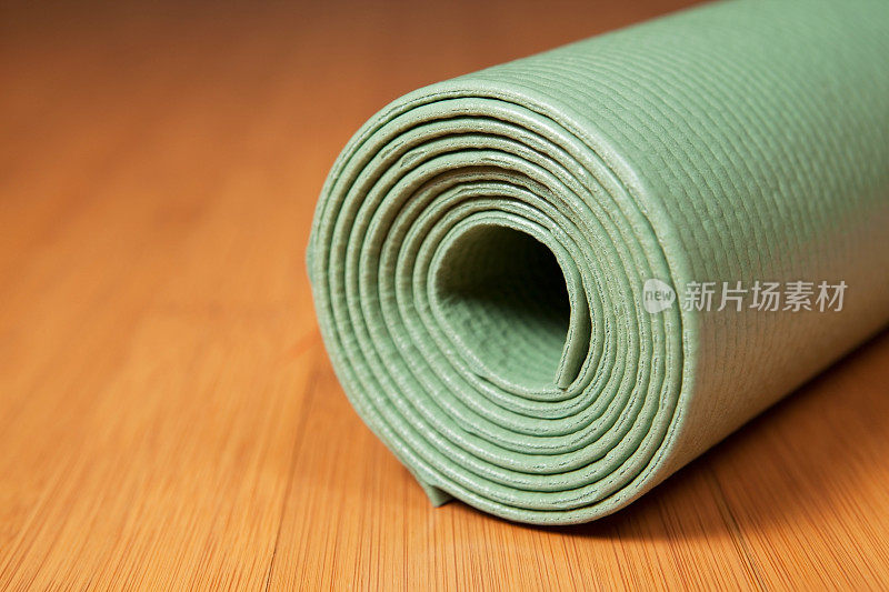 竹地板上的绿色瑜伽垫