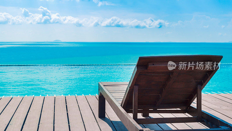 游泳池边的沙滩椅和蓝色的大海