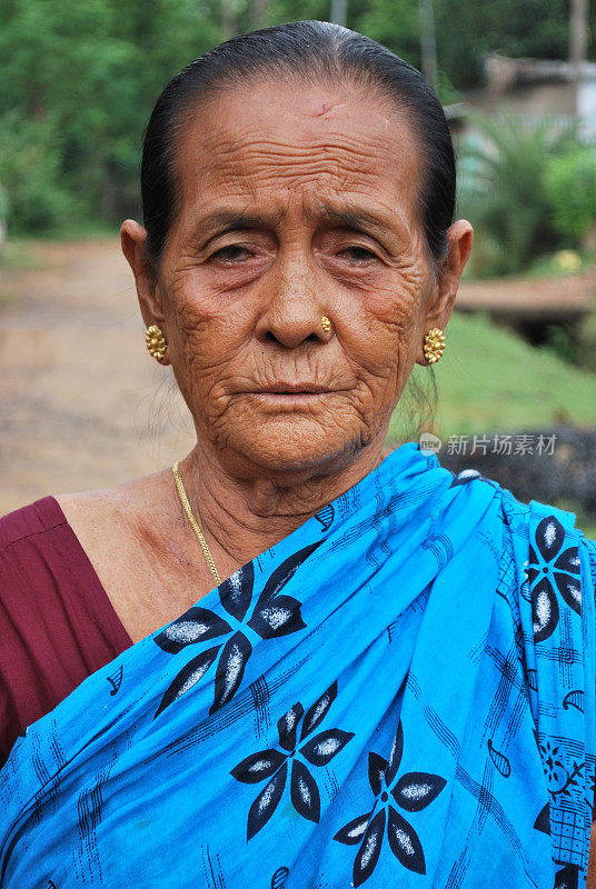 穿着蓝色纱丽、满脸皱纹的印度农村老年妇女
