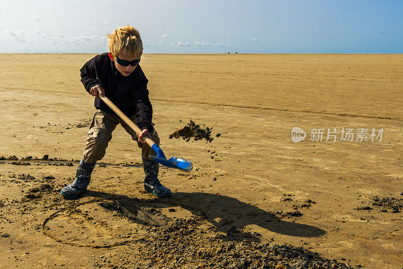 在圣彼得奥丁的海滩上，一个拿着铲子的男孩