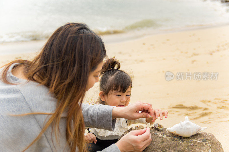 妈妈和小女孩在海滩上玩