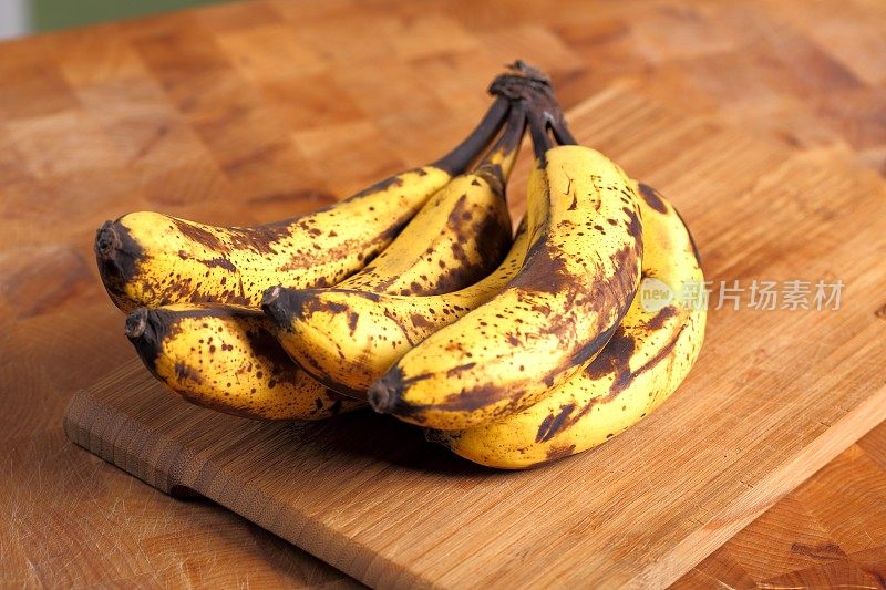 一串熟透的香蕉放在木头背景上