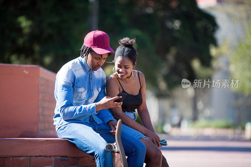 一对非洲夫妇在看他们手机上的照片