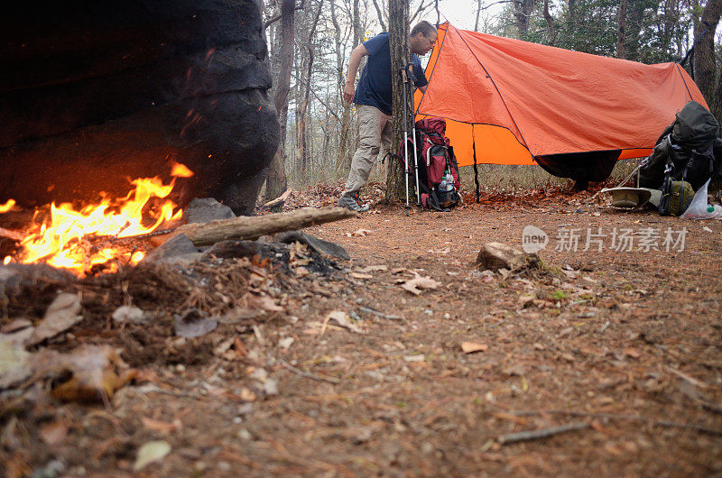 一名男子进入露营地的帆布吊床帐篷