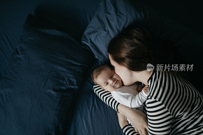 年轻的母亲和她刚出生的男婴躺在床上