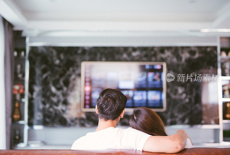后视图夫妇看电视在客厅