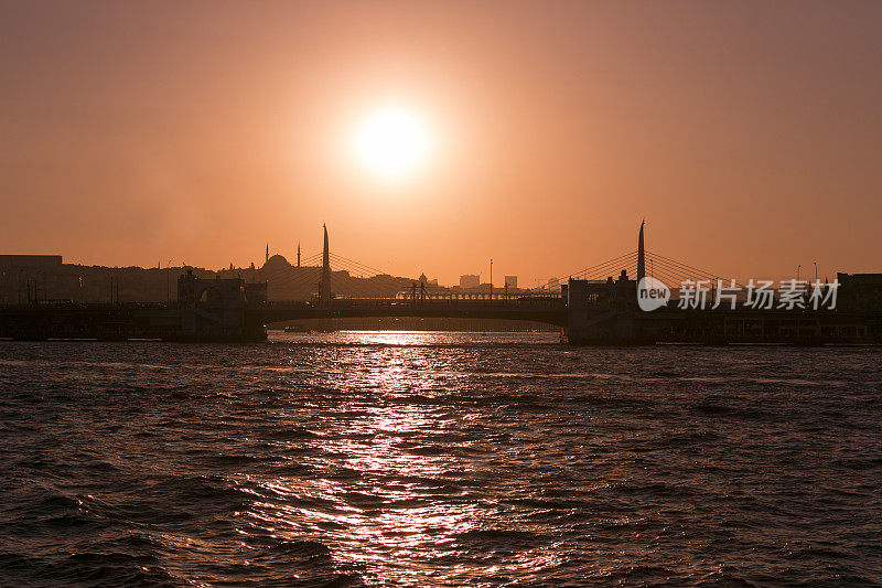 日落时分，土耳其伊斯坦布尔的米诺努阿克萨拉法提赫附近金角的加拉塔桥