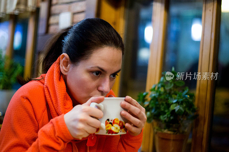 女人往茶杯里加蜂蜜的特写