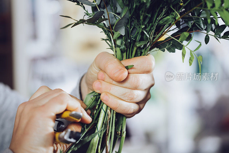 现代花匠工作与鲜花在车间-与手的细节