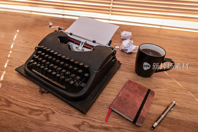 打字机和一堆皱巴巴的纸，还有一台老式打字机