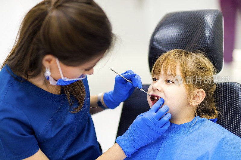 可爱的女孩牙齿检查在牙医的办公室