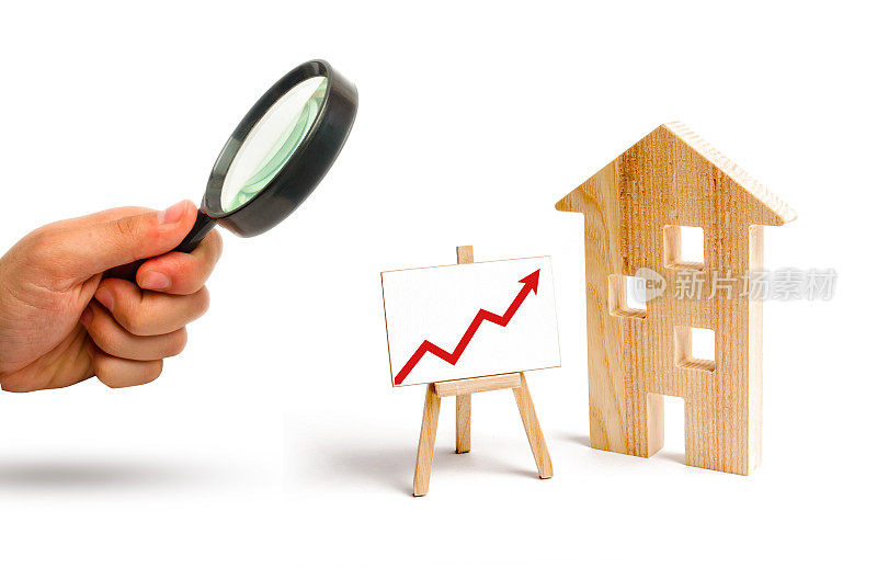 放大镜正看着红箭头指向的木屋架。不断增长的住房和房地产需求。城市的发展和人口。房价上涨的概念