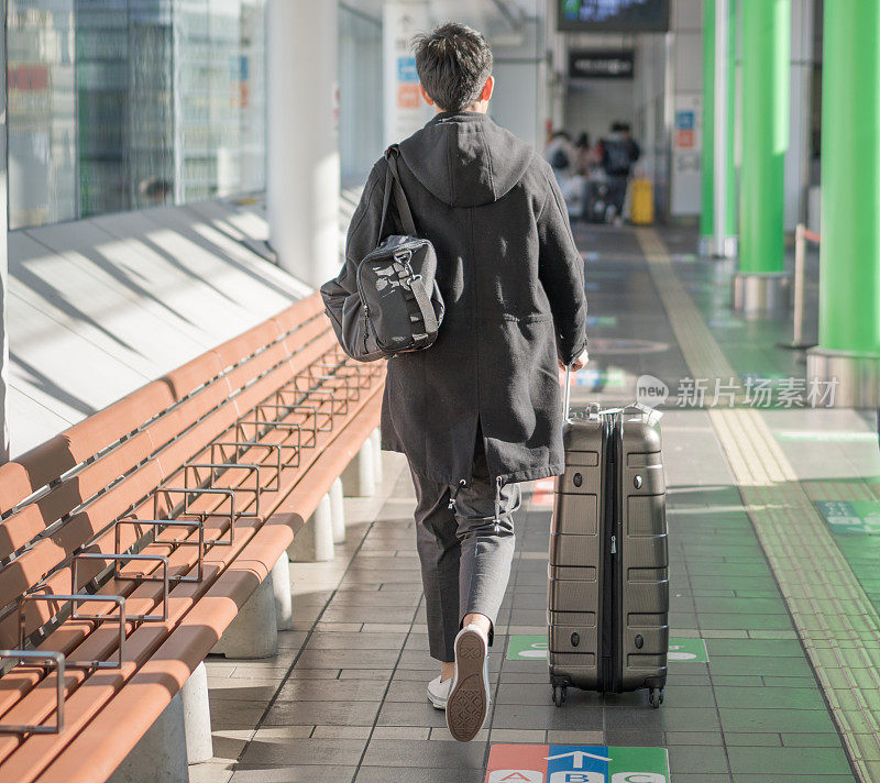 年轻的日本亚裔男子乘坐公共交通工具，在日本机场等待飞机