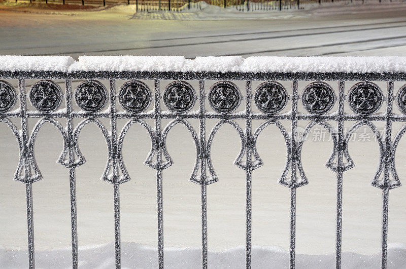 冬天，雪，夜，铁栏杆装饰元素沿着车道的小镇Tarko-Sale
