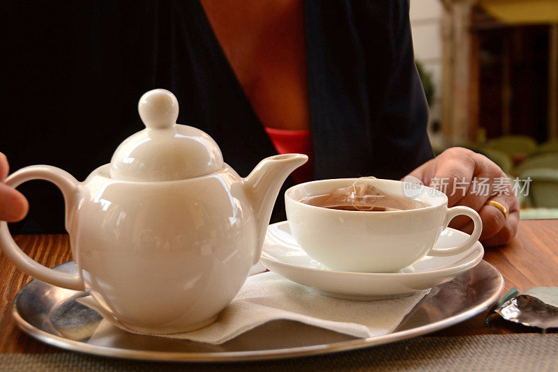 茶壶和装满水的杯子放在托盘上。