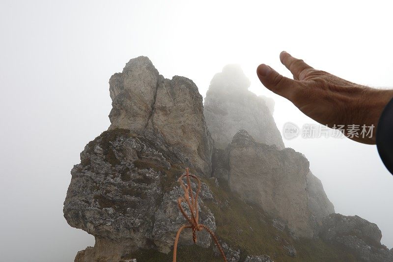 登山者把绳子扔到岩石顶峰