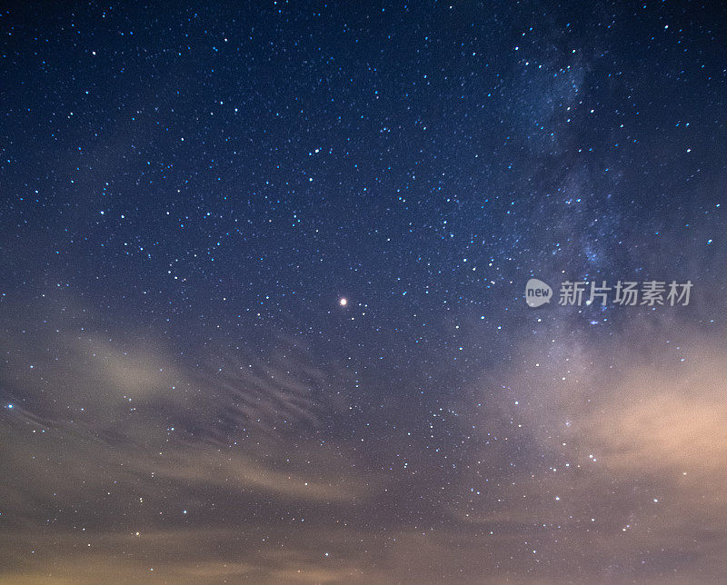 山上有银河和粉红的光。晚上多彩的景观。夏天的星空和山峦。美丽的宇宙。太空背景与星系。旅游的背景