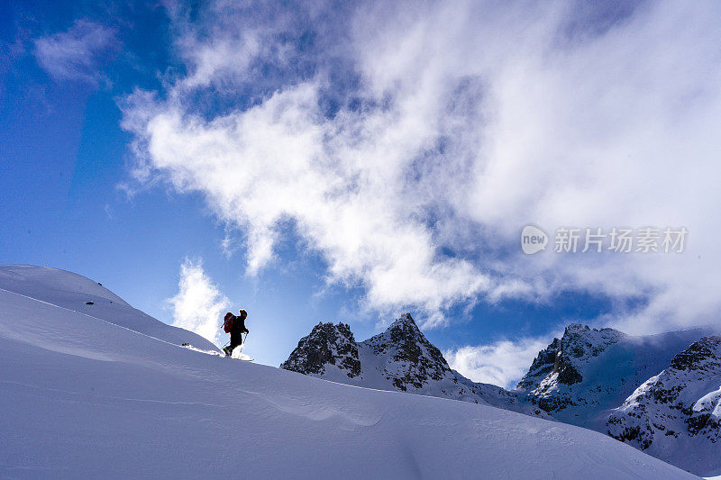 滑雪登山运动员攀登积雪的山脊线