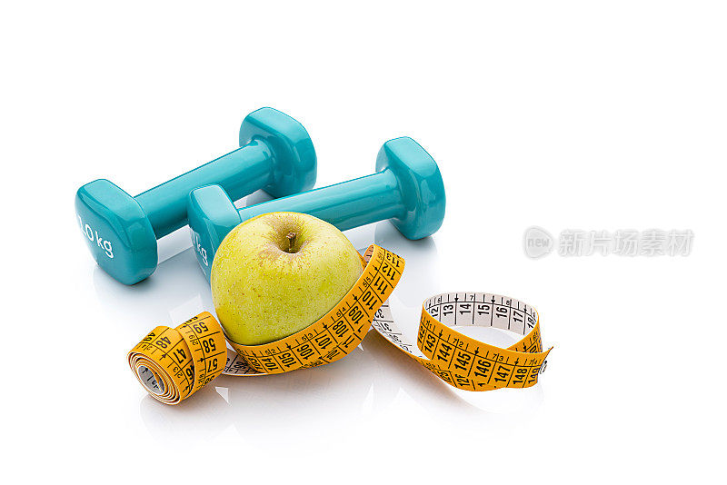 健康食品与健身理念:哑铃、苹果和卷尺上隔离白色