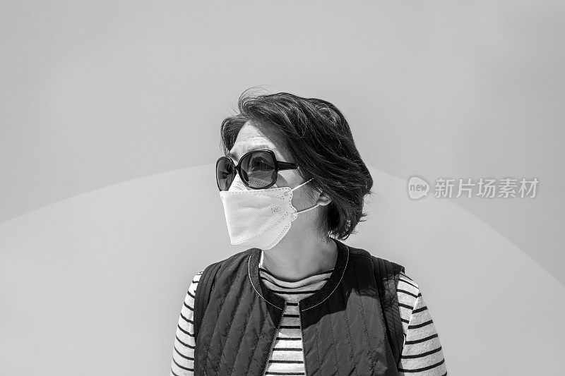 这是一位戴着医用口罩以抵御Covid-19病毒的妇女的特写