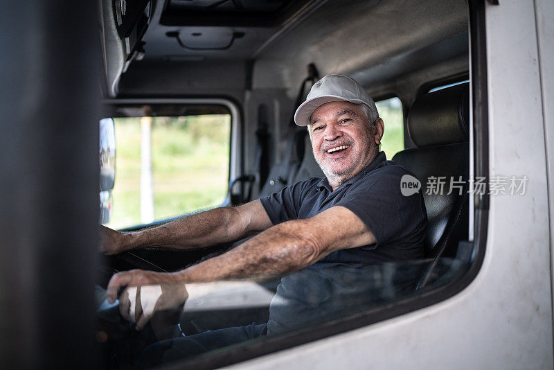 一位年长的男性卡车司机坐在驾驶室里
