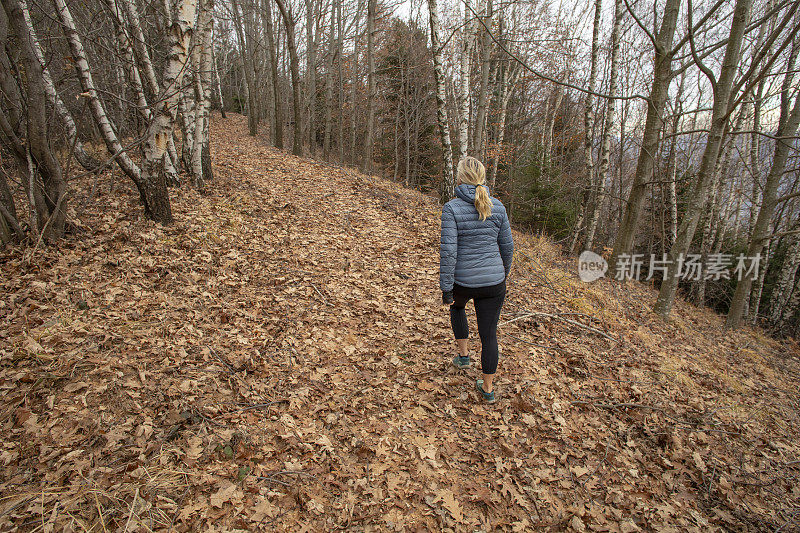 一个女人在森林里走过落叶