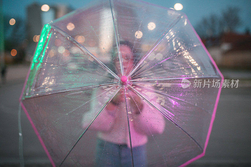 一个不知名的女人在雨夜撑伞