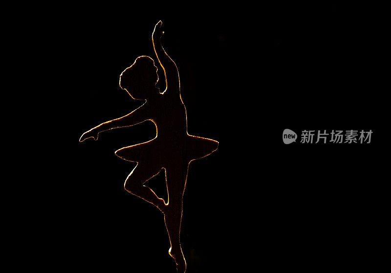 芭蕾舞女演员在黑暗背景上跳舞的剪影