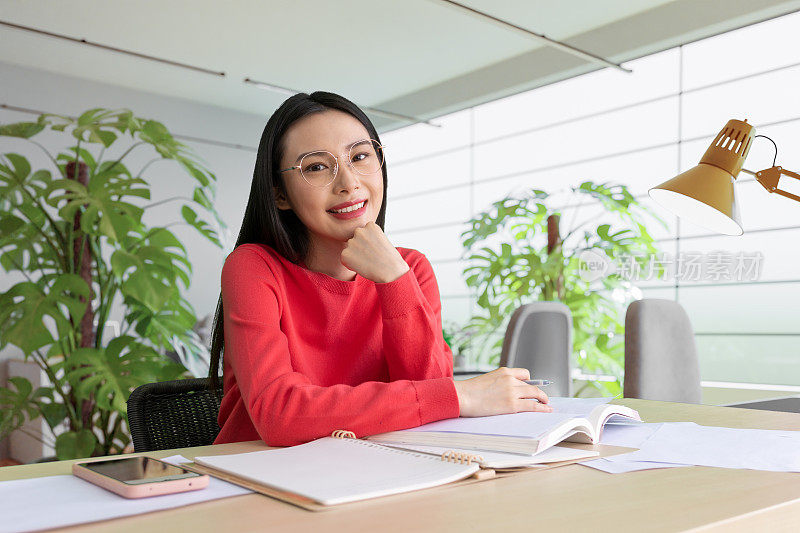 咖啡店里，女人用铅笔在笔记本上写字。在咖啡店户外工作的妇女。