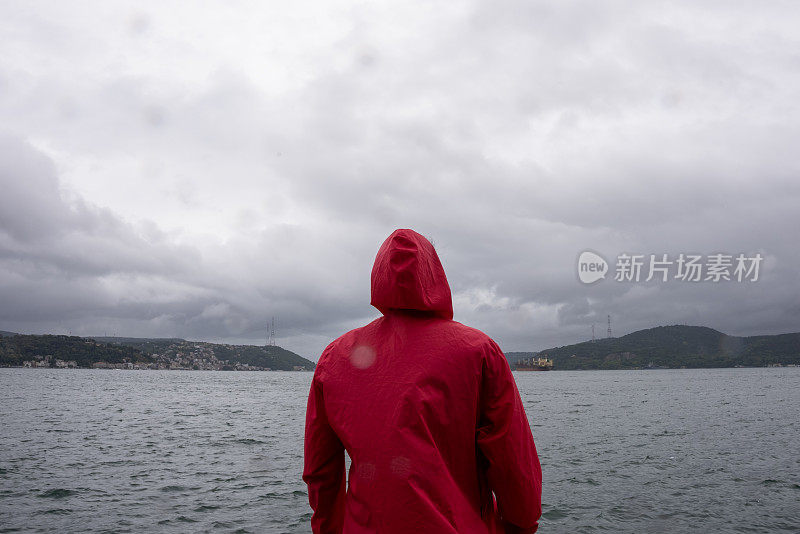 一个穿着红色连帽雨衣的男人独自在森林里