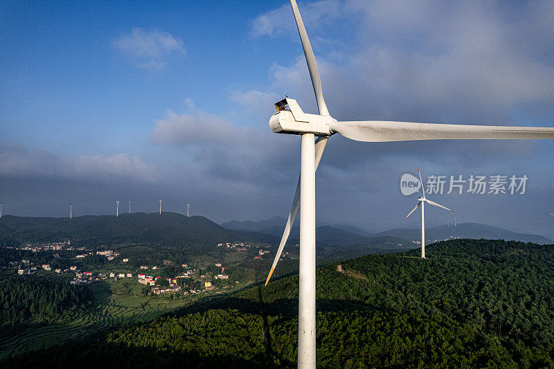 在阳光明媚的日子里，森林山上的风力涡轮机