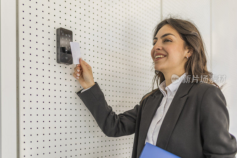 商务女性上班时面带微笑，戴上手机支票卡办理入住手续。