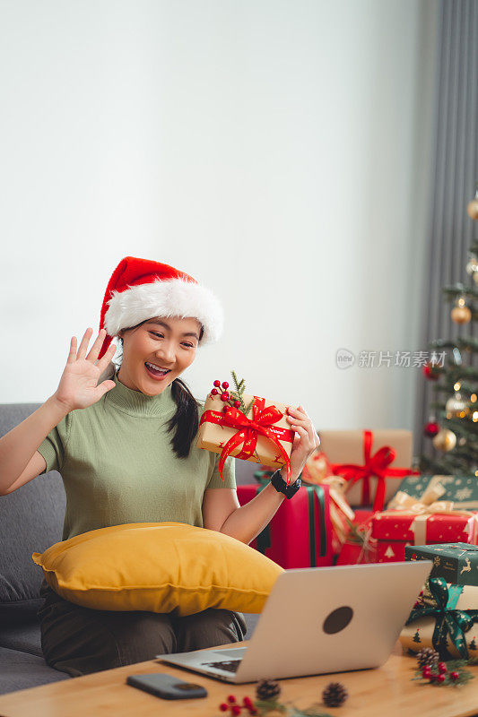 亚洲女性喜欢在圣诞节用笔记本电脑进行视频通话或视频直播。