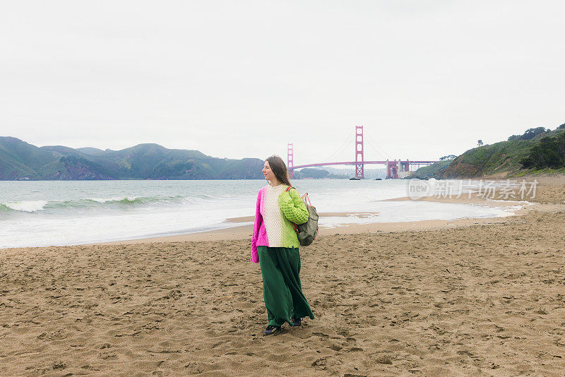 背着背包的女人在加利福尼亚旧金山的贝克海滩沉思